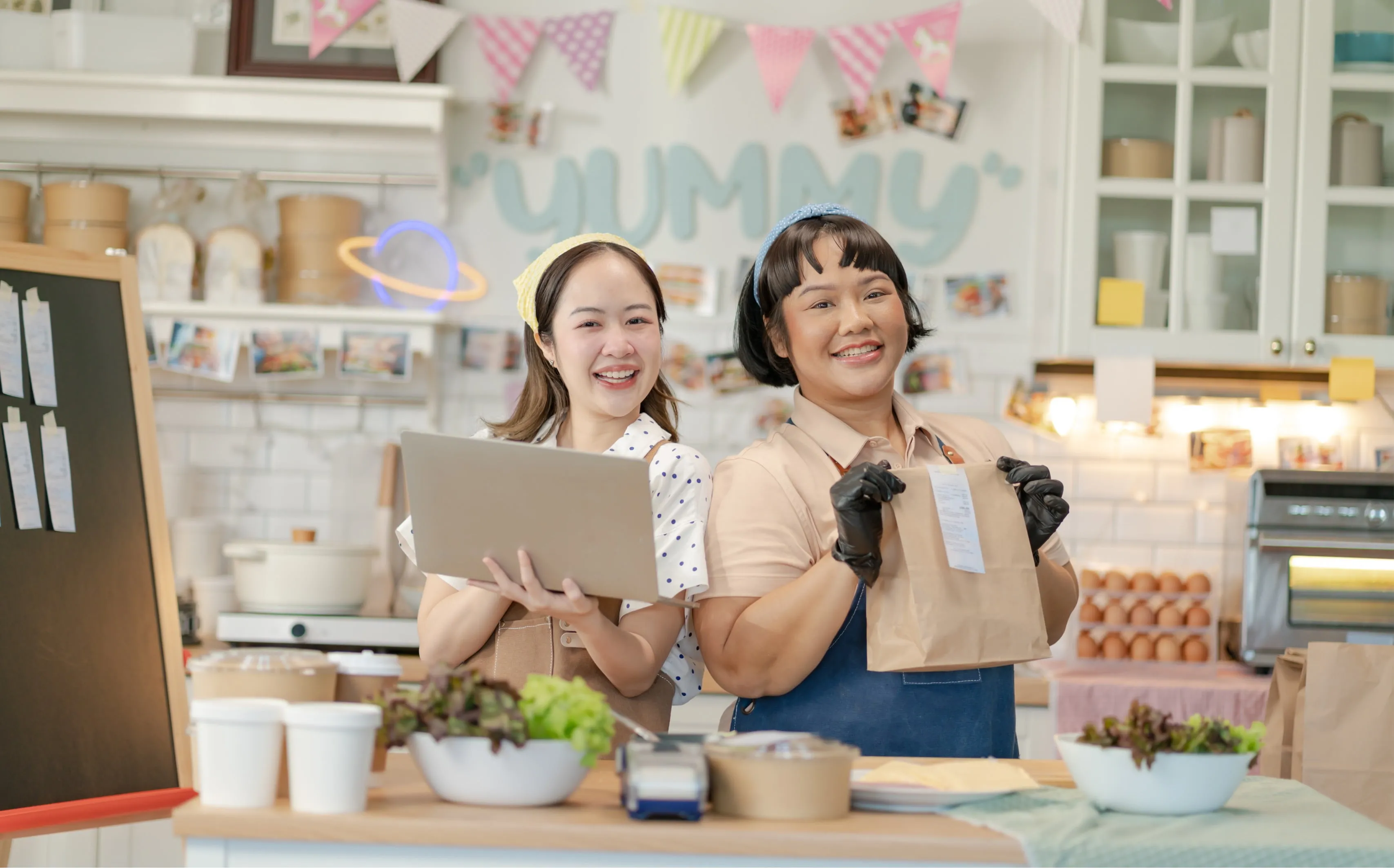 Kids with a laptop in a baking kitchen looking like they made some products.