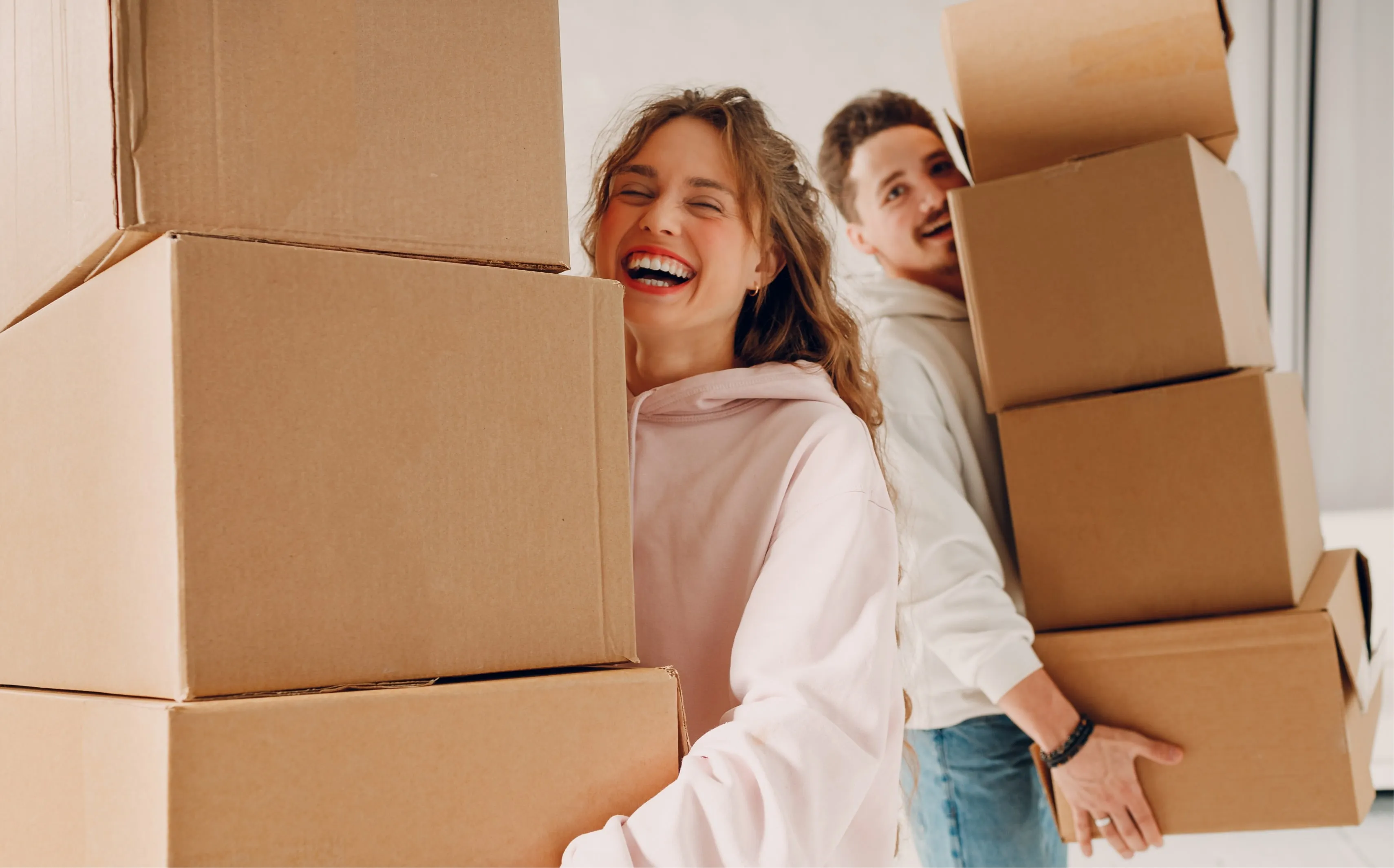 A young couple carrying a lots of moving boxes